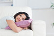 © WavebreakMediaMicro - Woman relaxing on a sofa while holding a pillow