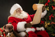 © Milles Studio - Portrait of happy Santa Claus reading Christmas letter or wish l