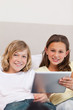 © WavebreakmediaMicro - Brother and sister using tablet on couch