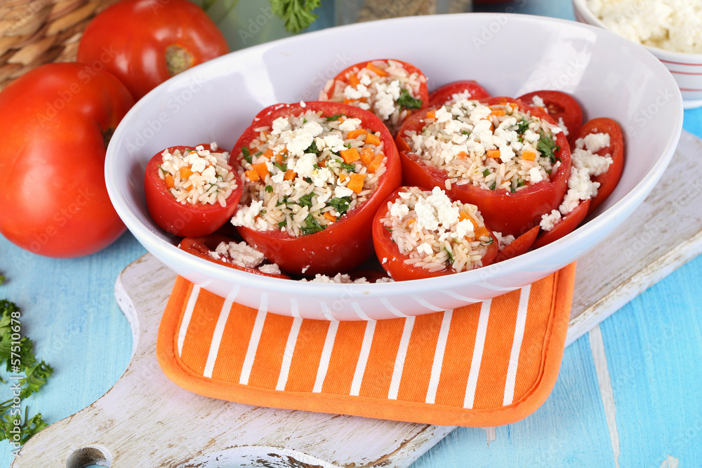 Stuffed tomatoes in bowl on wooden table close-up