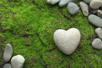 Wall Mural - Grey stone in shape of heart, on grass background