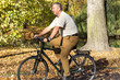 Man rides his bike through the park in autumn