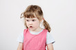 © singulyarra - Little surprised beautiful girl looks away on white background.
