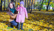 © travnikovstudio - Little girl with young mother in yellow autumn park on a warm