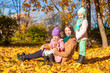 © travnikovstudio - Little girls and young mother in autumn park on sunny warm day