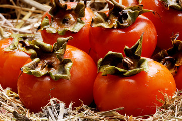 cloesup of Japanese persimmon fruits on the straw