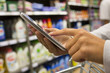 © ldprod - Woman using mobile phone while shopping in supermarket