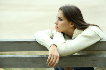 Wall Mural - Young lonely woman on bench in park