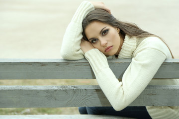 Wall Mural - Young lonely woman on bench in park