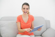 © lightwavemedia - Beautiful casual woman using her tablet looking cheerfully at ca