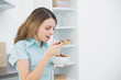 © lightwavemedia - Lovely woman eating cereals while standing in her kitchen