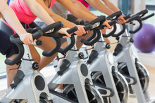 Mid Section Of People Working Out At Spinning Class