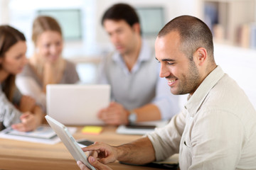 Young man in office working on digital tablet