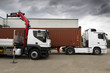 © meskolo - Camion con container che viene caricato da una gru. Due camion.