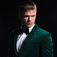 serious face of a young man wearing green velvet suit