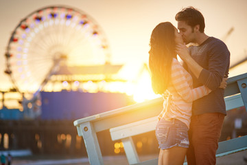 romantic couple kissing in front of santa monica