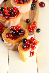 Canvas Print - Tasty muffins with berries on white wooden table