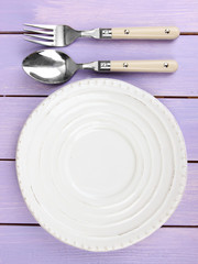 Canvas Print - Plate and cutlery on wooden table close-up