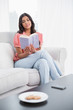 © lightwavemedia - Calm cute brunette sitting on couch reading