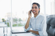© lightwavemedia - Young black haired businesswoman sitting at her desk