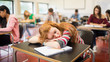 © WavebreakMediaMicro - Blurred students in the classroom with one asleep girl