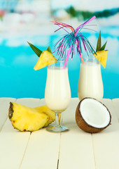 Poster - Pina colada drink in cocktail glasses, on bright background