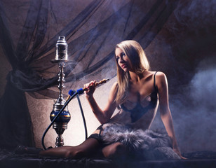 Wall Mural - A sexy woman in luxury underwear smoking a hookah