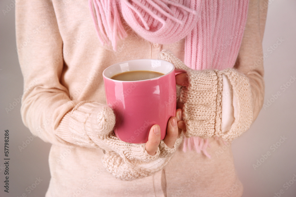 Female hands with hit drink, on light background