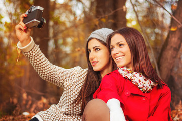 Attractive girls taking self portraits in the park