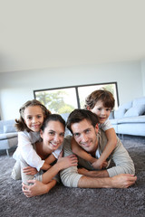 Fototapete - Family at home relaxing on carpet