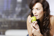 © Studio-FI - Woman lying on sofa with an apple