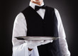 © Andrey Popov - Male Waiter Holding Tray