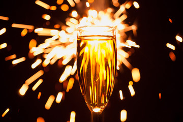 Wall Mural - champagne glass against christmas sparkler background