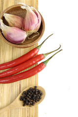 garlic heads in a wooden bowl and allspice in a wooden spoon