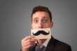 © ra2 studio - Happy businessman holding funny mustache card on his mouth
