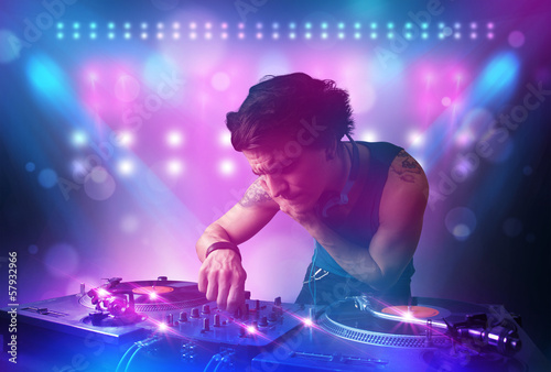 Plakat na papierze fotorealistycznym Disc jockey miksująca muzykę na gramofonach na scenie ze światłami i