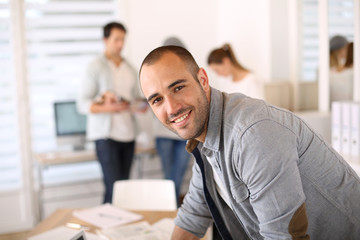 Aufkleber - Smiling young man in office working on laptop