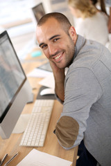 Aufkleber - Cheerful guy sitting in front of desktop computer