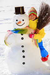 Wall Mural - Winter fun, happy kid playing with snowman