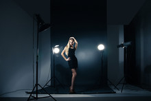Beautiful Woman Posing At Studio In Light Flashes