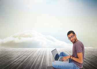 Poster - Composite image of man wearing glasses sitting on floor using la