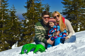  family having fun on fresh snow at winter vacation