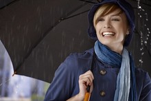 Young Woman Using Umbrella In Rain