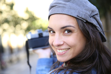 Portrait of trendy girl holding camera