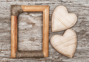 Wooden hearts and frame on the old wood