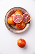 Ripe red oranges on white textured background