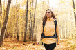 © gpointstudio - Smiling woman wearing yellow jacket walking in forest