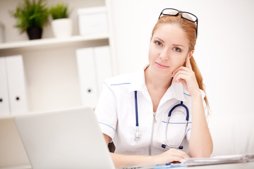 Portrait of a smiling physician working in her office