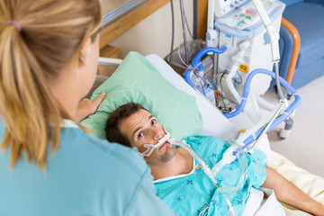 Wall Mural - Patient Looking At Nurse As She Adjusts His Pillow