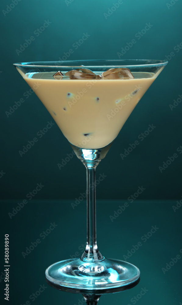 Baileys liqueur in glass on blue background